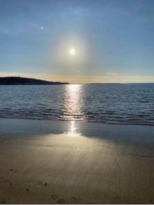 a beach with the sun setting over the water at Studio 61 fremington near instow in Fremington