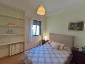1 dormitorio con 1 cama con manta azul y blanca en Casa de Adriana, en Nàquera
