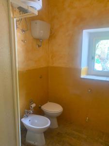 bagno con servizi igienici, lavandino e finestra di Casale San Francesco Casa Pernicoló a Cirò