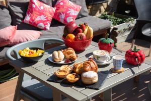 una mesa con una bandeja de bollería y fruta. en Lagos Uptown Bed & Breakfast, en Lagos