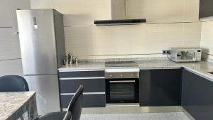 a kitchen with a stove and a refrigerator at La Libélula in El Espinar