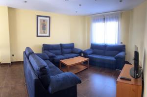 a living room with two blue couches and a table at La Libélula in El Espinar