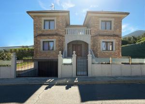 a brick house with a gate and a fence at La Libélula in El Espinar