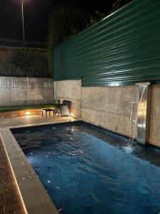 a swimming pool with a fountain at night at La Libélula in El Espinar