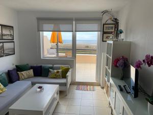 uma sala de estar com um sofá e uma mesa em Seaview Apartment 414 em Morro del Jable