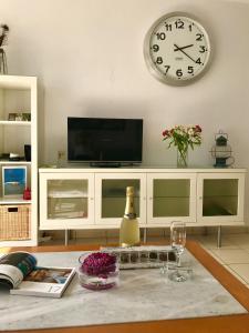 uma sala de estar com televisão e um relógio na parede em Seaview Apartment 414 em Morro del Jable