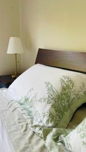 a bed with a wooden headboard and a pillow on it at COMFORT QUEEN GARDEN VIEW ROOM MACQUARIE PARK RYDE in Sydney
