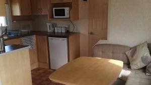 uma pequena cozinha com mesa e bancada em 3-Bed 8 berth static caravan in ingoldmells em Skegness
