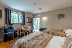 a hotel room with two beds and a television at Windermere Studio Rooms in Windermere