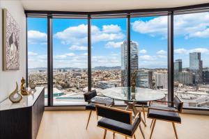 a room with a table and chairs and large windows at 3 Bed 3 Bath Penthouse at Prime Location in Los Angeles