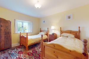 1 Schlafzimmer mit 2 Betten und einem Fenster in der Unterkunft The Wool Barn Simonsbath in Exford
