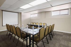 una sala conferenze con un lungo tavolo e sedie di Travelodge by Wyndham Fort McMurray a Fort McMurray