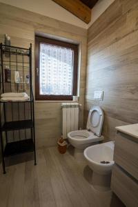 a bathroom with a toilet and a sink and a window at Roberta House in Isernia