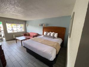 a hotel room with a bed and a chair at Rodeway Inn in Lake Wales