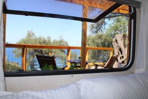1 dormitorio con ventana y vistas al porche en Nature Habitat en Vouniatádes