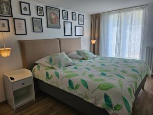 sypialnia z łóżkiem z zieloną i białą kołdrą w obiekcie le stockholm w mieście Sablons