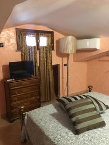 una camera con un letto e un comò con una televisione di Enza-home-in-ROMA a Borghesiana