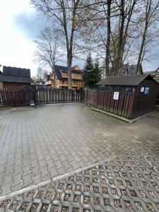 Un patio con una valla y una casa. en Apartament Śnieżka, en Zakopane