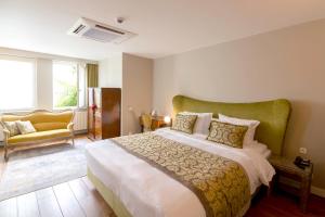 1 dormitorio con 1 cama grande y 1 sofá amarillo en Hotel 'T Sandt, en Amberes