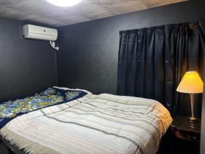 a bedroom with a bed and a lamp and a window at Tokurajyo - Vacation STAY 15813 in Akiruno