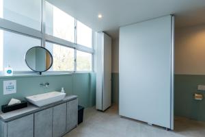 a bathroom with a sink and a mirror at SAKIA stay in Awaji