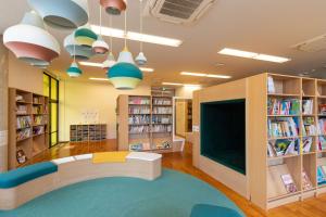 a library with a large tv and bookshelves at SAKIA stay in Awaji