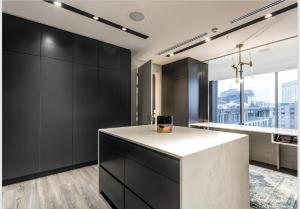 a kitchen with black cabinets and a white island at The RoyalPlatinum Penthouse in Johannesburg