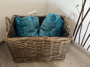 a wicker basket sitting on the floor with blue pillows at Ferienwohnung TAUNUSIDYLLE 