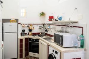 a kitchen with a white refrigerator and a microwave at La Casetta di Giò! in Castellammare del Golfo +23 photos