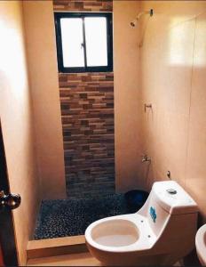 a bathroom with a toilet and a window at Hacienda Antonio Function Hall and Resort in Pampang