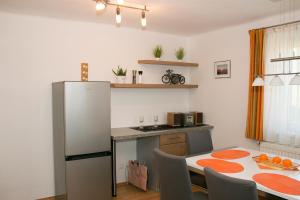 a kitchen with a refrigerator and a table with chairs at Haus Edler in Gleinstätten