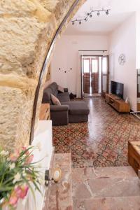a living room with a couch and a tv at La Casetta di Giò! in Castellammare del Golfo