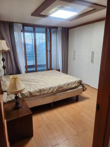 1 dormitorio con 1 cama y 1 lámpara en una mesa en house for rest, en Geoje