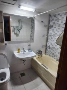 a bathroom with a sink and a toilet and a tub at house for rest in Geoje
