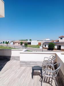 un patio avec deux chaises et un banc sur le toit dans l'établissement Loft de 50metros con dos terrazas, à Herencia