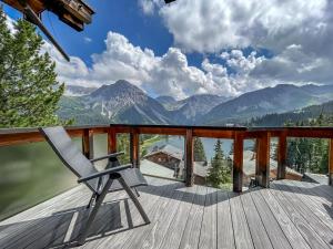 a chair on a deck with a view of mountains at Seeblick in Arosa