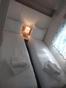 Uma cama ou camas num quarto em Tree tops - 2 bedroom static caravan with decking
