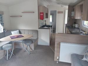 a small kitchen with a table and a counter top at Tree tops - 2 bedroom static caravan with decking in Hastings