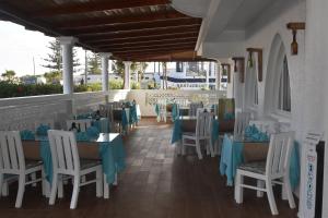 un restaurante con mesas y sillas con servilletas azules en Hotel L'Initiale, en Oualidia