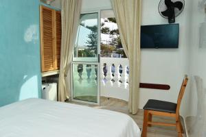 a bedroom with a bed and a window at Hotel L'Initiale in Oualidia