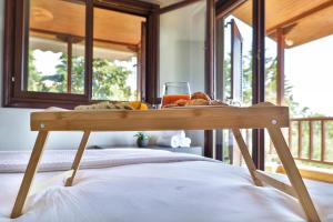 a tray of bread and a drink on a bed at Iconic PRIVE beachfront villa Mola Kaliva in Mola Kalyva