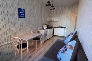 een kleine kamer met een tafel en een keuken bij Наримановская 66-5, Уютная 1 комнатная квартира ВИП класса в Jana Qala от компании Home Hotel in Qostanaj