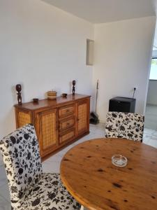 a dining room with a wooden table and two chairs at villa avec piscine in Somone
