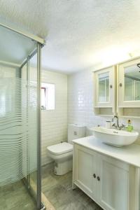 a bathroom with a sink and a toilet and a shower at Original stone house with patio in the city center in Alacati