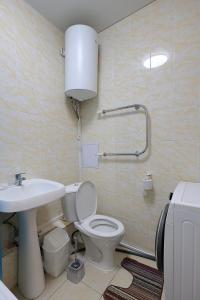 een badkamer met een wit toilet en een wastafel bij Наримановская 66-5, Уютная 1 комнатная квартира ВИП класса в Jana Qala от компании Home Hotel in Qostanaj