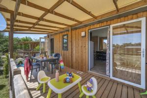 a house with a deck with a table and chairs at fort bedmar in Sint-Gillis-Waas