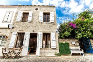 a stone house with a bench in front of it at Original stone house with patio in the city center in Alacati