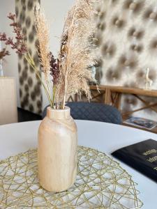 a vase with dried grass on a table at Open-Water-Resort in Geierswalde