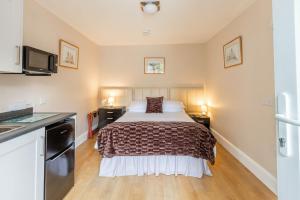 a small bedroom with a bed and a kitchen at Roger Ground Guest House - with Onsite Car Parking in Windermere