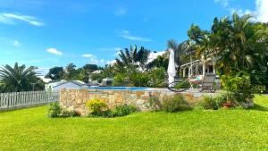 a yard with a swimming pool and a fence at VACANCES OUEST REUNION in La Possession